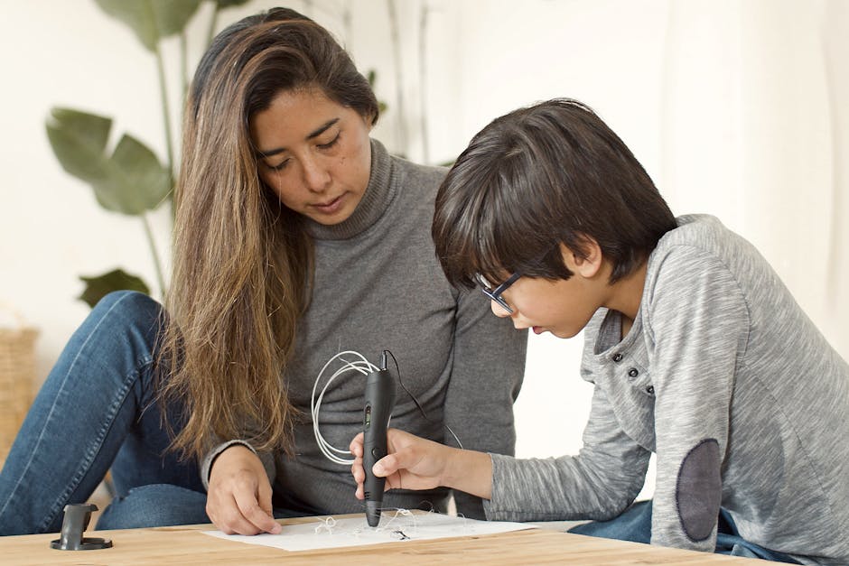 A mother and son focused on a creative project using a 3D pen. Perfect for themes of family, technology, and creativity.